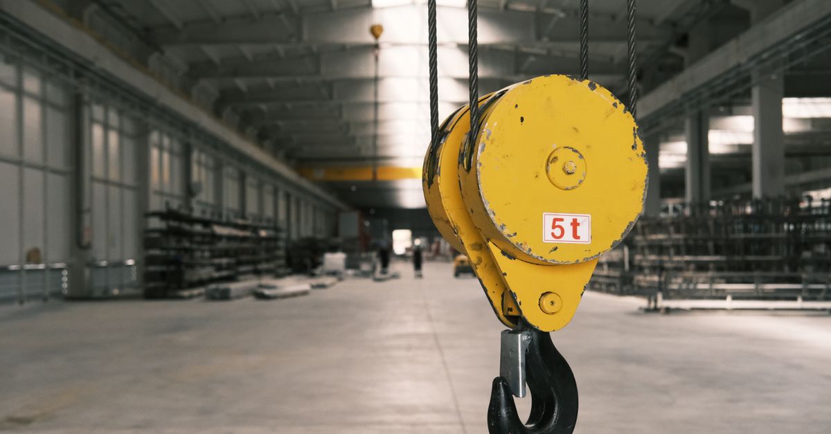 Closeup of a 5-ton yellow crane hook in an empty warehouse in Konya, Türkiye.